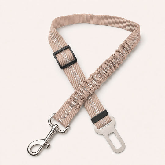 Beige SafeBelt adjustable dog car seat belt on a warm cream background