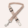 Beige SafeBelt adjustable dog car seat belt on a warm cream background