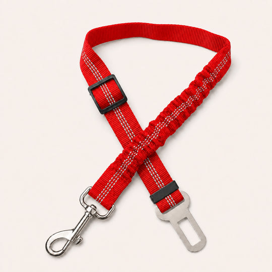 Red SafeBelt adjustable dog car seat belt on a warm cream background